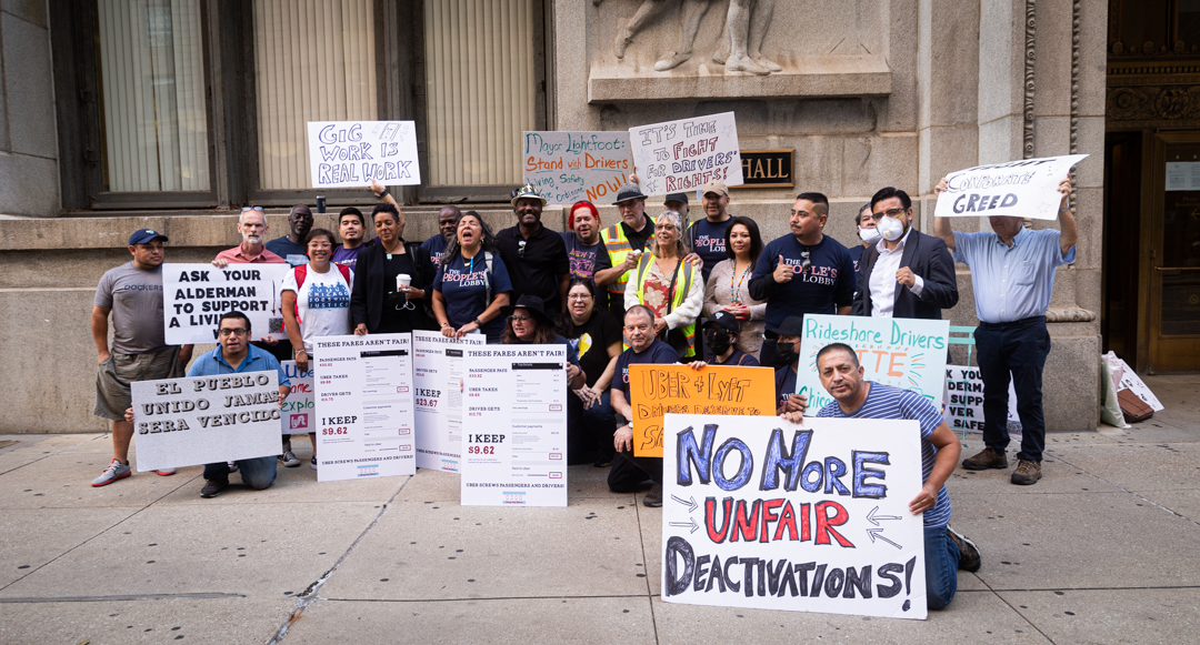 A group of protestors with signs about Gig Workers’ Rights facing the camera.